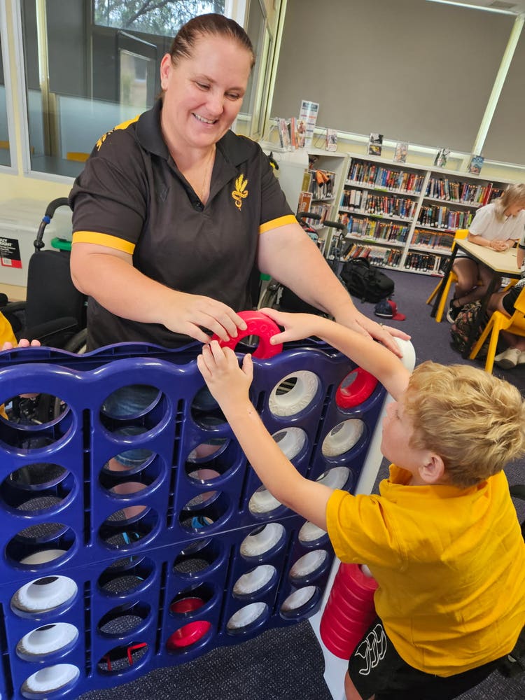 slso with student engaging in a game of connect four