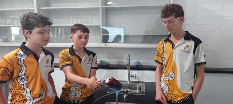 3 students using in science classroom participating in Bunsen burner activity